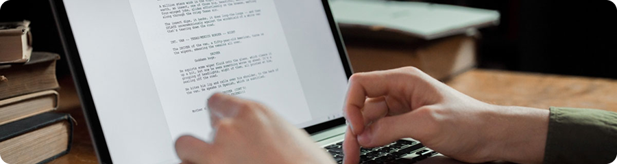 Tay gõ laptop kèm sổ sách hướng dẫn